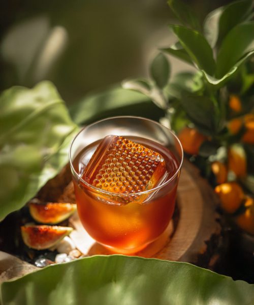Artisan cocktail with gold-toned garnish, served in natural light